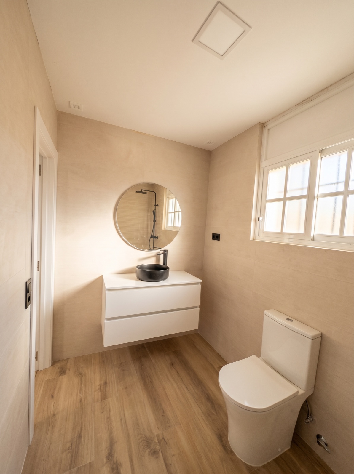 Renovated bathroom in a Cádiz flat with a flush-to-floor shower tray and fixed glass screen